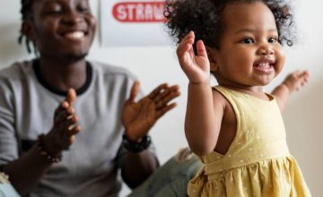 Happy parent clapping while toddler learning to walk