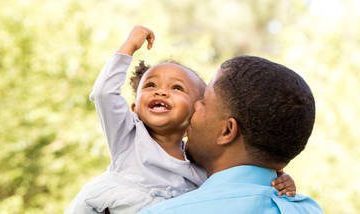 Father kissing baby daughter on the cheek