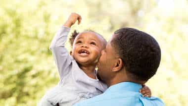 Father kissing baby daughter on the cheek