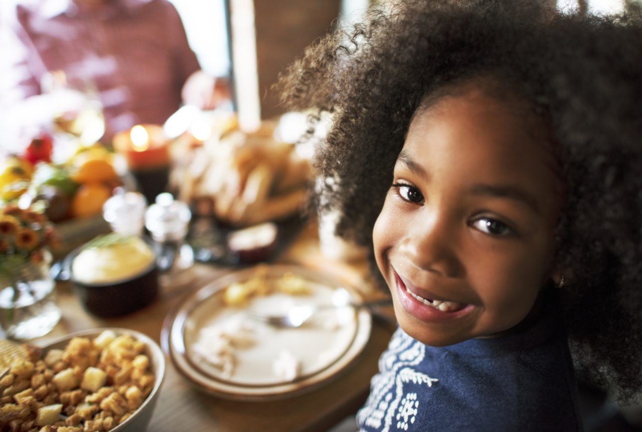 child eating at table and smiling