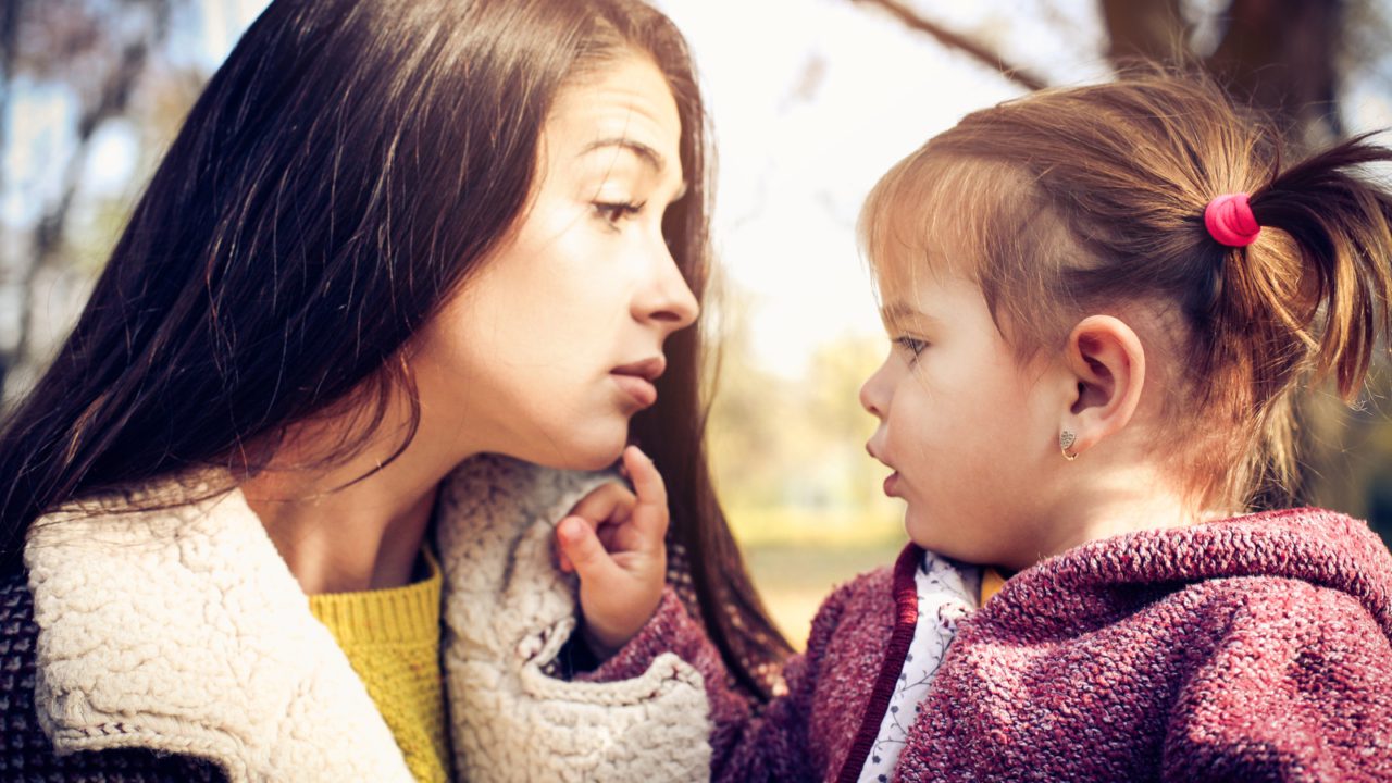 Toddler girl touching mother's face