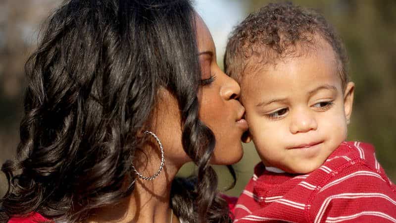 Mother kissing young toddler