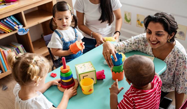 Adults playing with toddlers and their toys