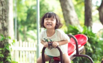 Toddler playing on a see saw