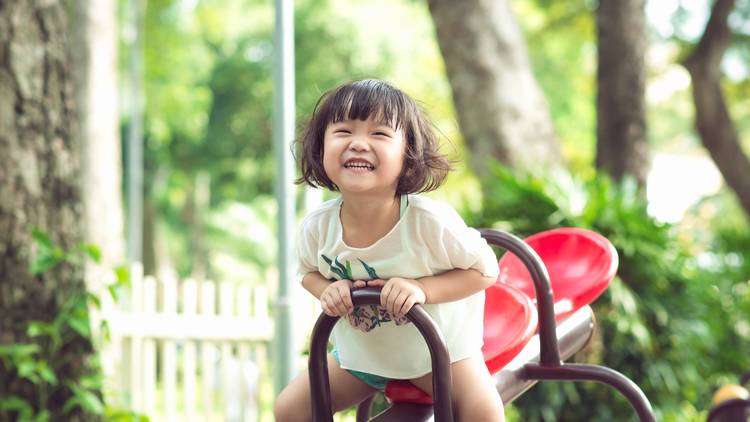 Toddler playing on a see saw