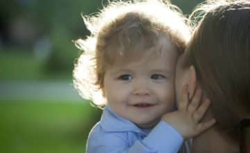 Smiling baby being held by parent