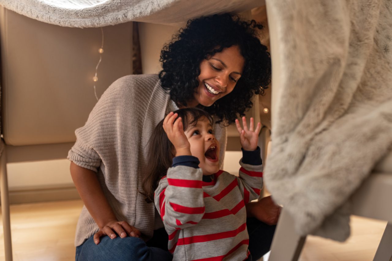 Toddler and mother in blanket fort