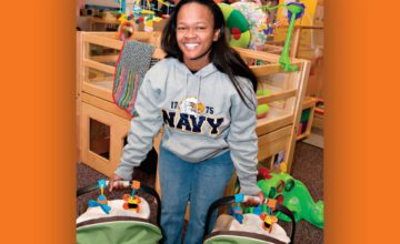 woman with Navy military sweatshirt holding two infants in car seat carriers