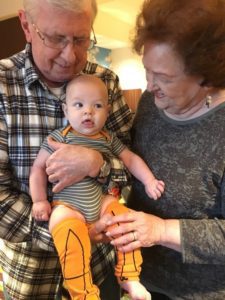 grandparents holding infant