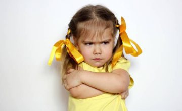 Toddler girl with arms crossed and upset