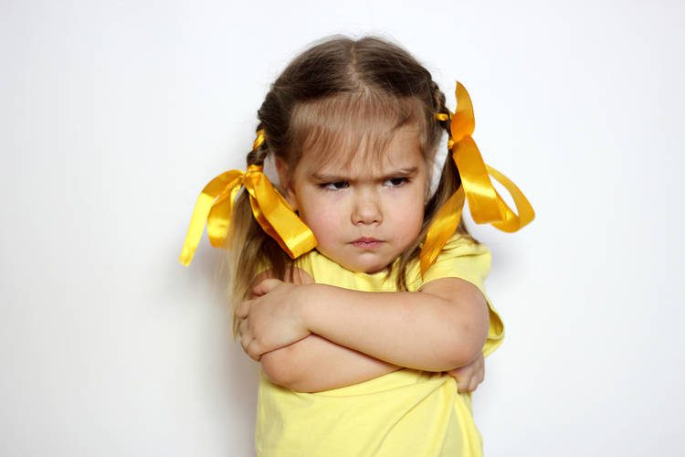 Toddler girl with arms crossed and upset
