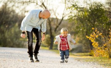 MAn walking on rocky path with toddler