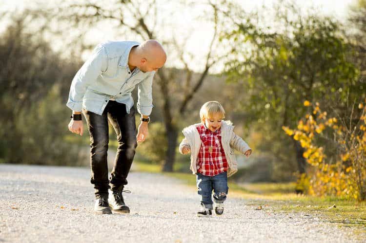 MAn walking on rocky path with toddler