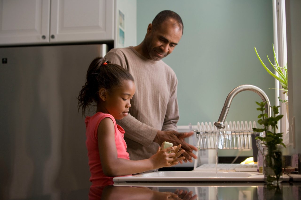 Father and daughter wash dishes