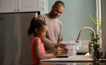 Father and daughter wash dishes