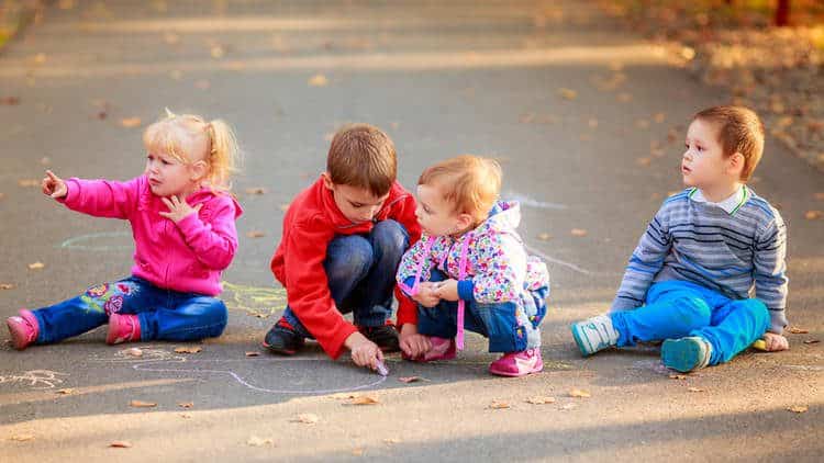 4 toddler chalk painting in the middle of a leaf will dry leaves in autumn clothes