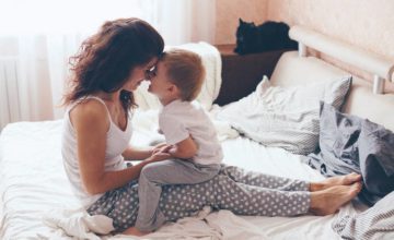 Woman and child nose to nose in a bed