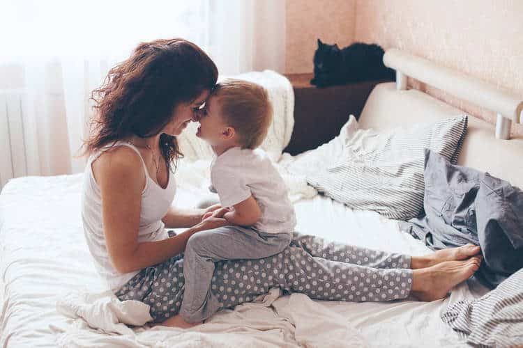 Woman and child nose to nose in a bed