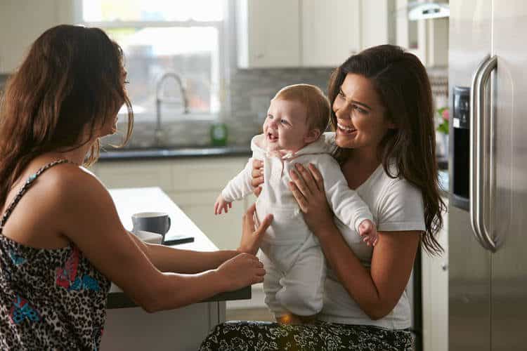 And infant and two women in a kitchen