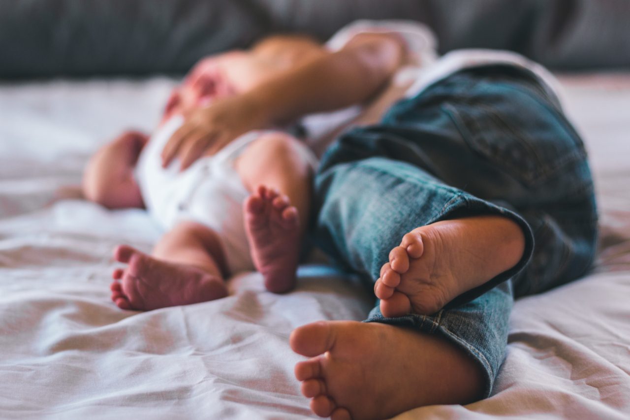 dad and baby lying down in bed