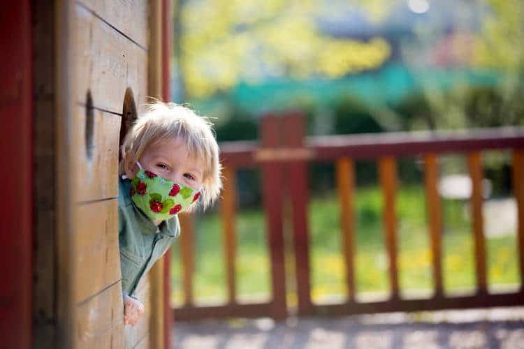 toddler with mask on playground