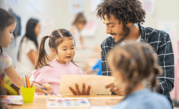 childcare man shows paper to child