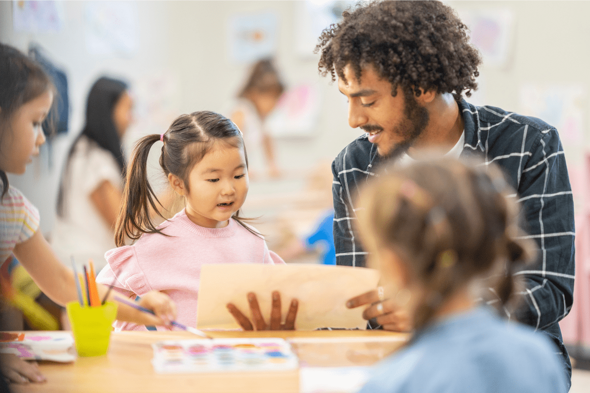 childcare man shows paper to child