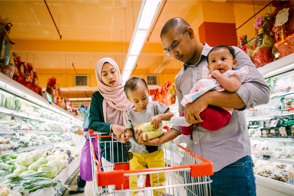 parents and two babies grocery shopping