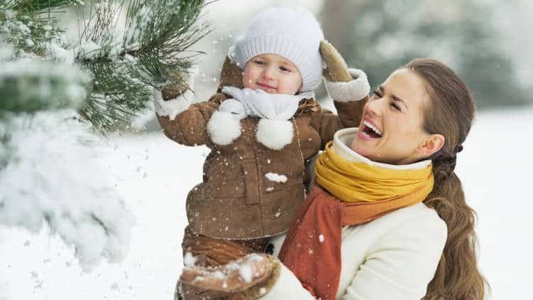 mom holding baby in snow gear