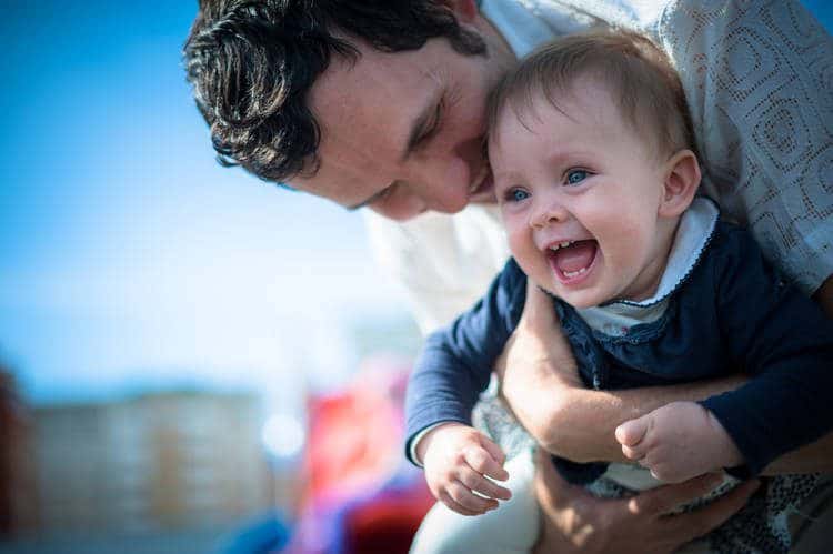 Parent laughing and hugging their toddler