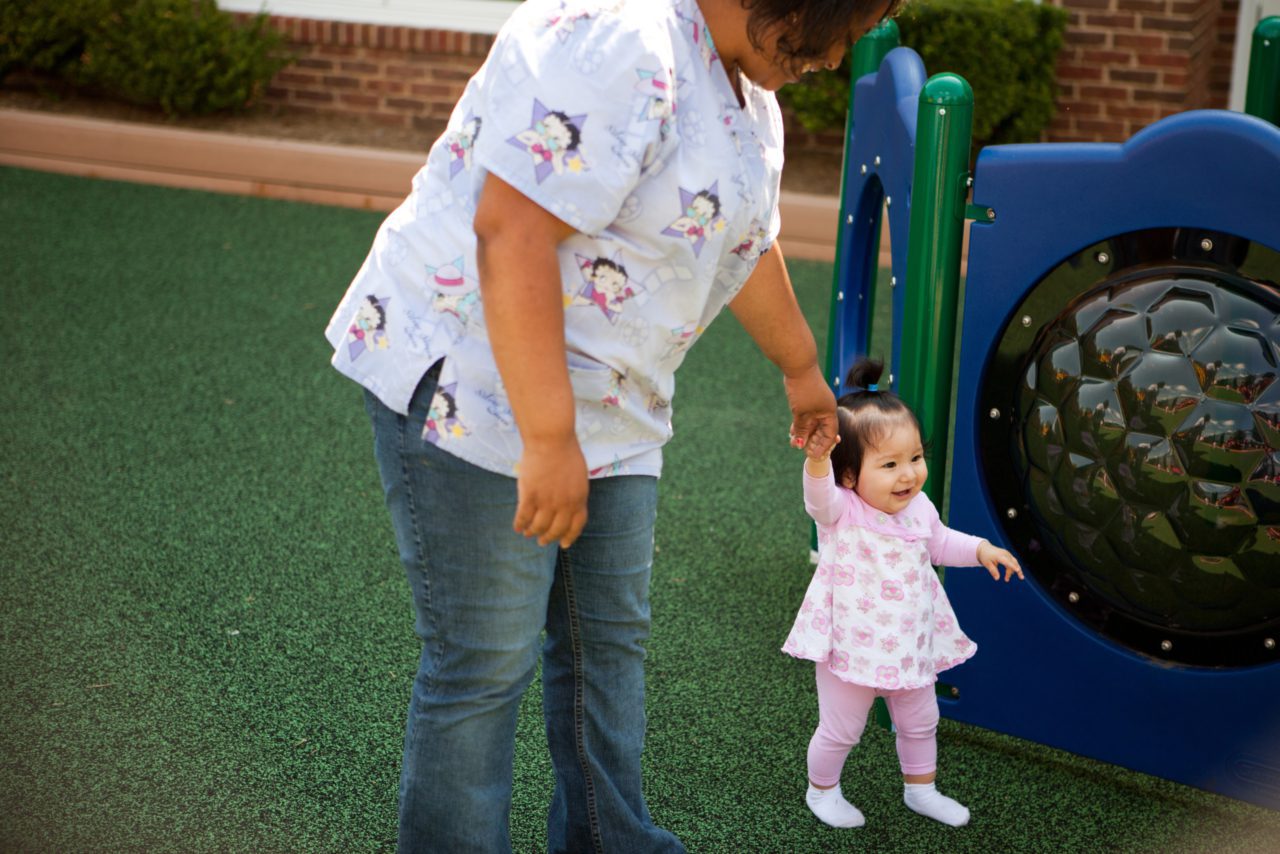 woman and small child play at playground