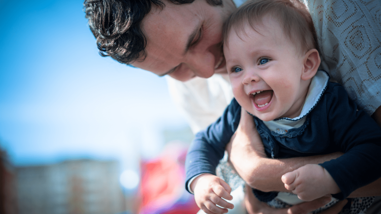 father holding kid laughing