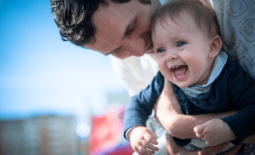 father holding kid laughing