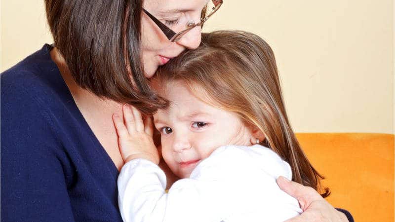 Caregiver comforting a shy child