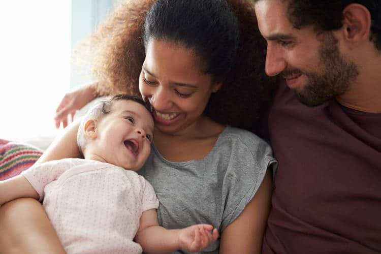 Parents smiling and holding smiling baby