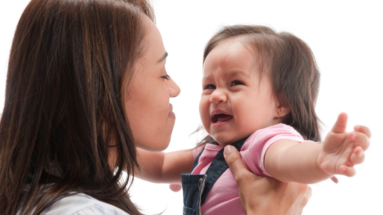 woman holds crying baby