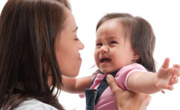 woman holds crying baby