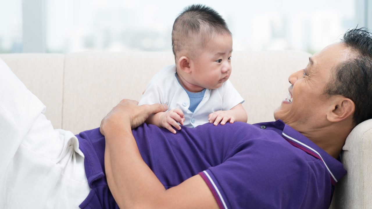 A child sits on their father's lap.