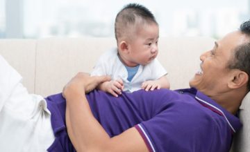 A child sits on their father's lap.