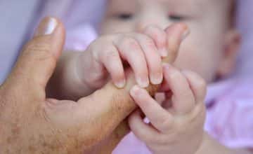 baby grabs adult finger