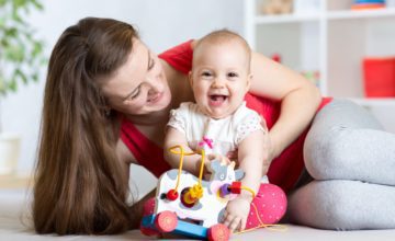 baby laughing and playing on floor