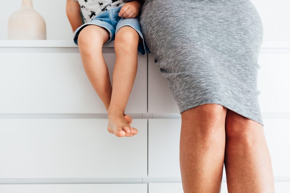 person in squirt sitting next to child in shorts