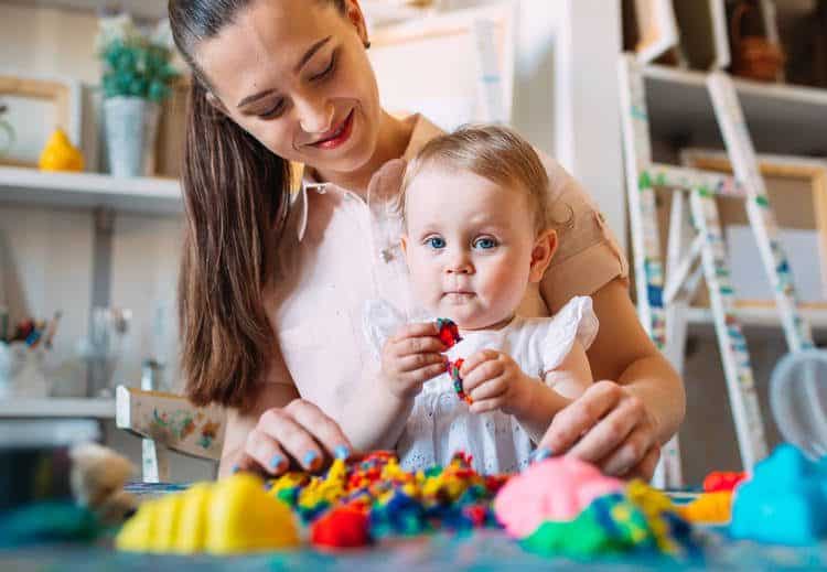 Parent sitting with child and toys