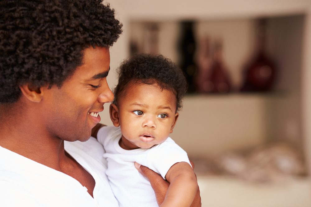 father holding baby in arms