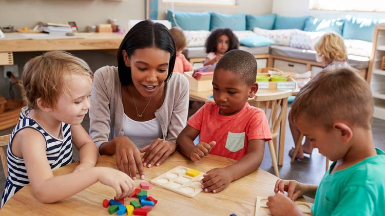 Child care professional with toddlers playing and learning