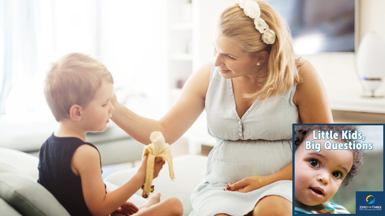 young boy eating banana as mother smiles at him