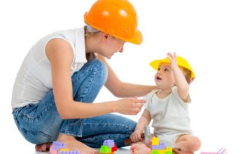 Parent playing with toddler wearing construction hats