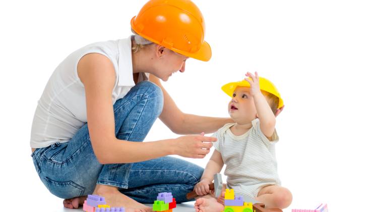 Parent playing with toddler wearing construction hats