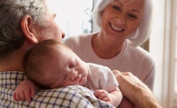 grandparents hold sleeping baby