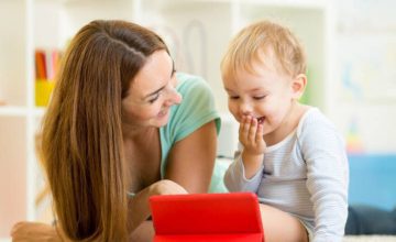 Mom and baby looking at screen together and laughing